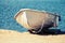 White rowboat stands on the sandy coast