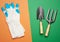 White rubber gloves and garden set of shovels, rakes, pitchforks