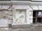 White ruinous facade with a broken window of an abandoned house. photo