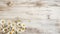 white rustic wooden texture table top view with blossoming daisies spring flowers and scattered petals, with copy space