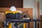 White safety helmets blueprints on the engineering desks. Hard safety wear helmet hat on desks at construction site