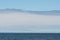 White sailboat cruising an a clam Salish Sea, San Juan Islands, blue sky with white clouds in the background