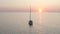 White sailboat floating on calmness Black sea water surface on sunset surrounded by nature scenery