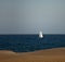 White sailboat glides across a deep blue ocean