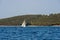 White sailboat on glistening blue water