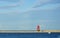 White Sailboat and Red Lighthouse in Harbor