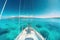 white sailboat sailing around some paradisiacal islands. View from the deck to the bow, mast, sails. Ai generative