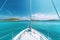 white sailboat sailing around some paradisiacal islands. View from the deck to the bow, mast, sails. Ai generative