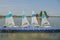 White sailboats dock on lake.