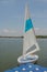 White sailboats dock on lake.