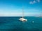 White sailing boat catamaran on ocean near beach