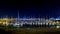 White sailing boats at harbour at night against dark blue sky