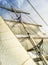 White sails, mast and ropes view from below of a classic sailing ship.