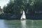 A white sails sailboat maneuvers on the River Thames near Richmond, London