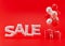 White sale text with balloons and presents on the red background. Special offer, good price, deal, shopping. Black