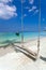 White sand beach near the blue sea. Boat, shade trees