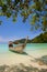 White sand beach at ocean with long boat in Tropicana country under clear sky