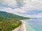 White sand beach with thick coconut trees and blue sea water located near Villa Ghost, West Lombok, Indonesia