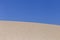 White sand dunes on summertime in Portugal, blue sky background. Holidays and relax concept
