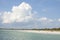 White sandy beach and blue sky with clouds