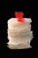 White sanitary individually wrapped napkin pads in stack on black background. Menorrhagia, heavy menstruation bleeding