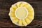 White saucer with corn sticks, bowl with condensed milk on wooden table. Top view