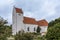 White scandinavian church with a tall tower against the blue sky