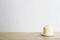 A white scented candles on wooden table over a light background.