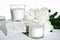 white scented soy wax candles on a natural stone and peony flowers. floral fragrance for cozy home. aromatherapy and