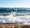 White sea foam on the top of the wave beating and splash to the shore and surface of pebble beach