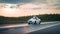 White self-driving car on the track at sunset