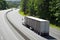 White semi truck long trailer on turn of highway