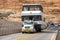 White Semi Truck With Oversize Load Sign Transporting Large Digger