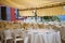 White served tables on the terrace under a yellow canopy