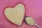 White sesame seeds in the shape of a heart on a pink background, top view. Super food ingredient. Healthy vegan concept
