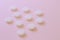 White set of pills on pink background