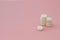 White set of pills on pink background