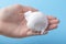 White shaving foam in the hand of a teenager on a blue bright background