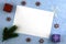 A white sheet on a blue surface framed by green fir twigs gift boxes of lollipops and snowflakes is a conceptual letter to Santa