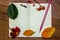A white sheet of a notebook, autumn yellow and green leaves, berries of a guelder-rose, a pencil on a wooden background.
