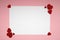 White sheet of paper for message to a loved one on a pink background with shiny hearts. Happy valentines day. Flat lay Layout.