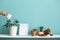 White shelf against pastel turquoise wall with pottery and succulent plant. Hand watering potted schefflera plant