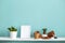 White shelf against pastel turquoise wall with pottery and succulent plant with potted snake plant