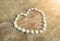 A white shell heart shape on a illuminated wooden floor symbolizes love for a Valentine\\\'s Day gift