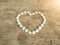 A white shell heart shape on a illuminated wooden floor symbolizes love for a Valentine\\\'s Day gift