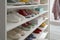 White shelving unit with collection of colorful sneakers