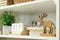 White shelving unit with deer figure, books and calendar