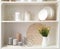 White shelving unit with dishes and decorative stuff