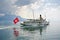 A white ship, a ship with the Swiss flag floats on a mirror lake of Geneva