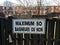 White sign on a fence with text [ 50 Baigneurs ou Non]  in Montreal, Canada